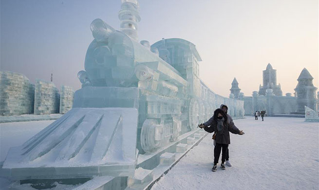 Tourists enjoys ice sculptures at Harbin Ice-Snow World in NE China's Heilongjiang