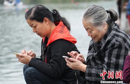 图为中国中老年女性使用智能手机上网。(资料图) 刘占昆 摄