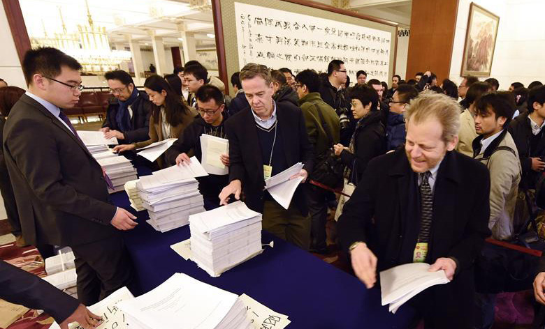 记者在人民大会堂内领取大会相关文件